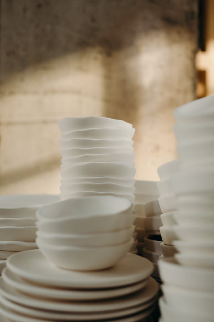 Aesthetic arrangement of porcelain bowls casting shadows and light indoors.